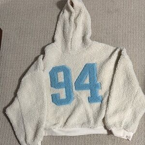 Brand new without tags cream colored Sherpa hoodie with light blue 94 lettering